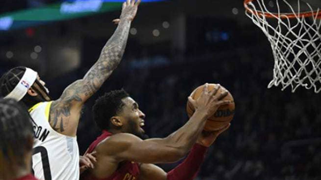 Cleveland Cavaliers guard Donovan Mitchell (45) shoots beside Utah Jazz guard Jordan Clarkson (00) in the second quarter at Rocket Mortgage FieldHouse.