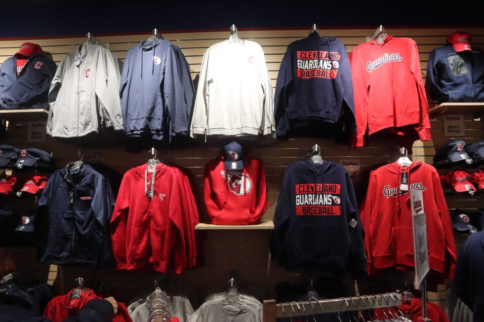 Cleveland Guardians gear, including shirts, sweatshirts, and caps, settle along the walls of the new team shop on Friday, Nov. 19, 2021.