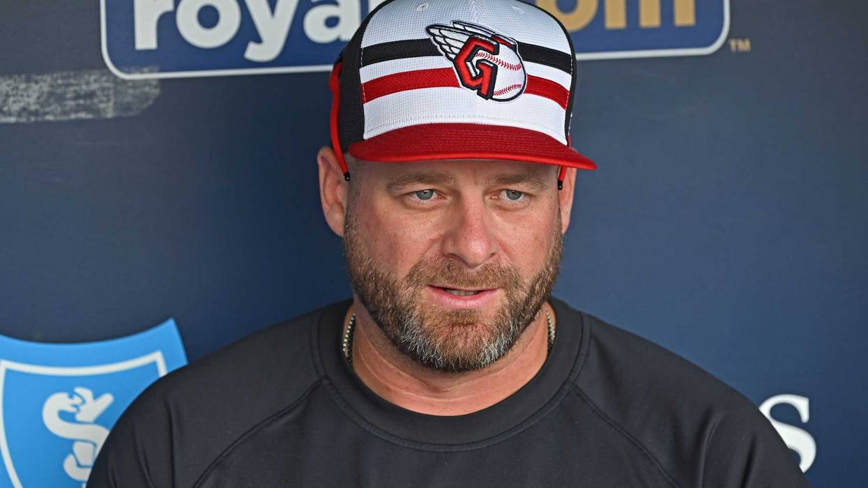 Cleveland Guardians manager Stephen Vogt (12) looks out from the dugout during batting practice before a game against the Kansas City Royals at Kauffman Stadium.