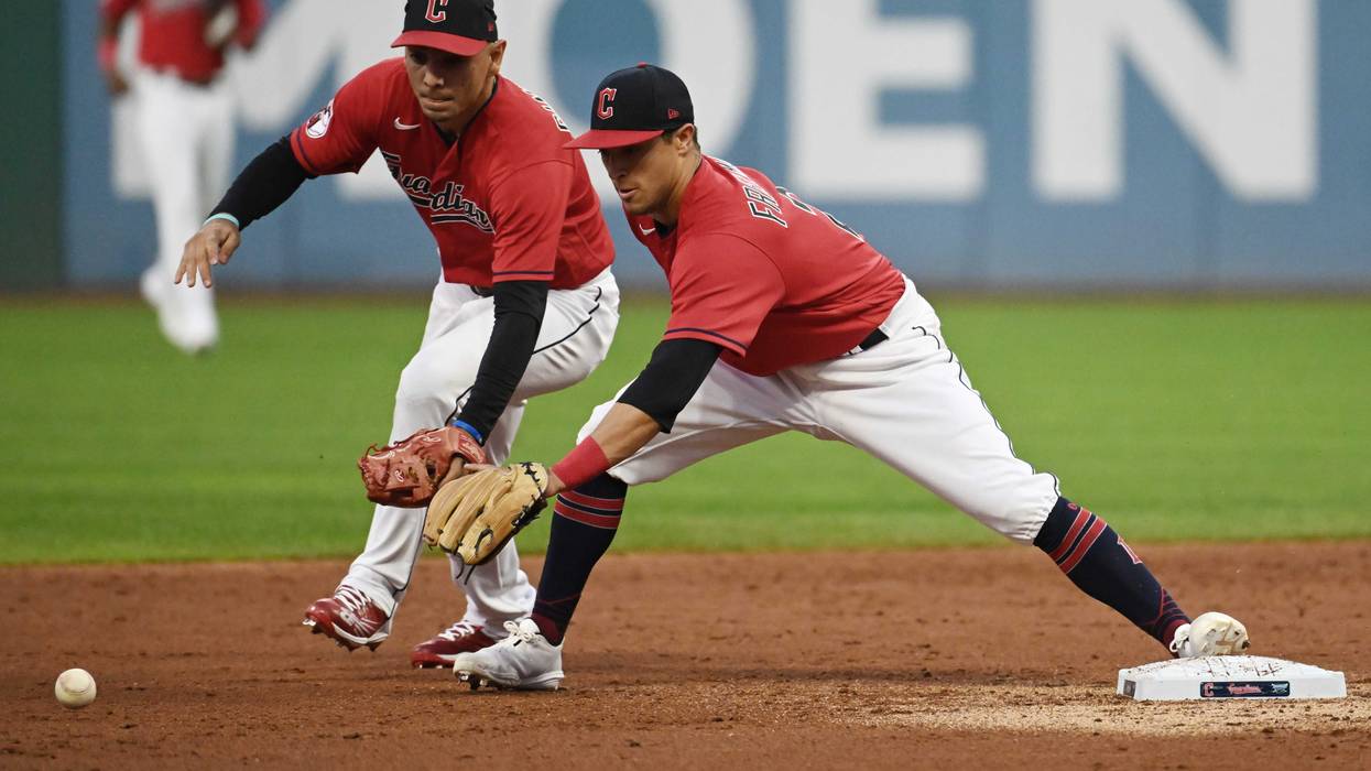 Cleveland Guardians second baseman Andres Gimenez, left, and shortstop Tyler Freeman reach for an errant throw from third baseman Jose Ramirez (not pictured) during the second inning against the Seattle Mariners at Progressive Field.