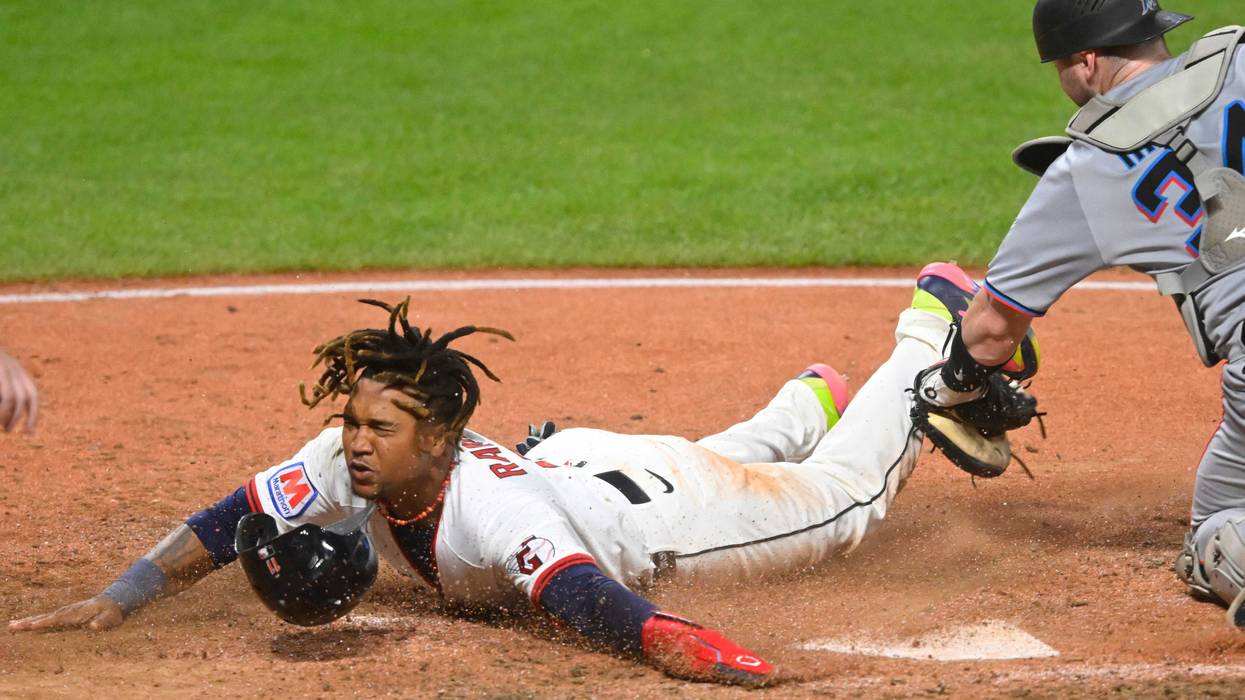 Cleveland Guardians third baseman Jose Ramirez (11) scores beside Miami Marlins catcher Liam Hicks (34) in the seventh inning at Progressive Field.