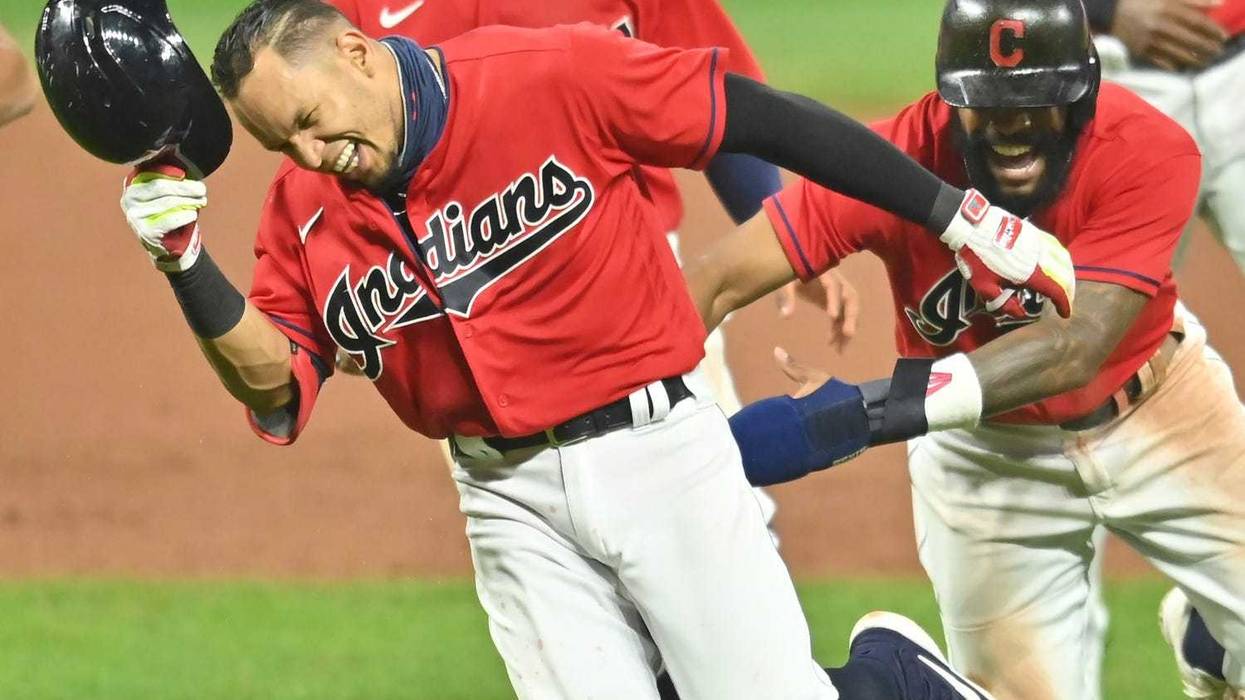 Cleveland Indians center fielder Delino DeShields (0) chases second baseman Cesar Hernandez (7) after Hernandez won the game with an RBI single during the ninth inning against the Pittsburgh Pirates at Progressive Field.