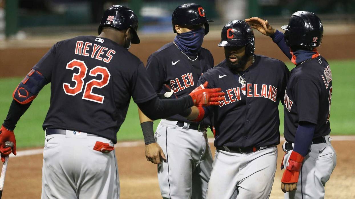 Cleveland Indians designated hitter Franmil Reyes (32) and second baseman Cesar Hernandez (7) and shortstop Francisco Lindor (12) congratulate first baseman Carlos Santana (middle right) on his three run home run against the Pittsburgh Pirates during the tenth inning at PNC Park.