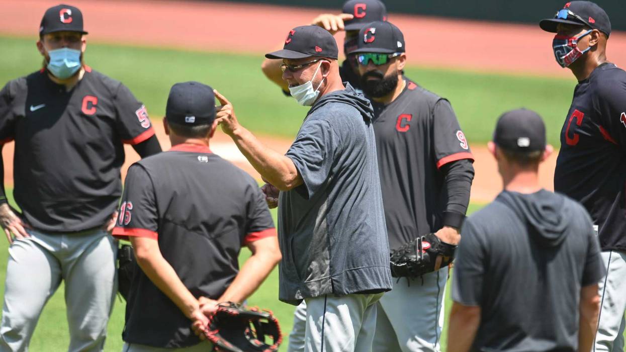 Cleveland Indians manager Terry Francona (middle, mask on chin)