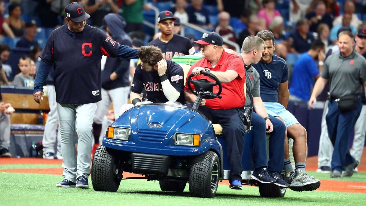 Cleveland Indians right fielder Tyler Naquin (30) is greeted by manager Terry Francona (77) while being carted off the field after an apparent injury at the end of the fifth inning against the Tampa Bay Rays at Tropicana Field.