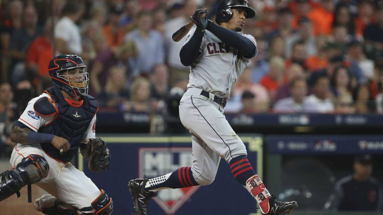 Cleveland Indians shortstop Francisco Lindor (12) hits a single in front of Houston Astros catcher Martin Maldonado (left) during the sixth inning in game one of the 2018 ALDS playoff baseball series at Minute Maid Park.