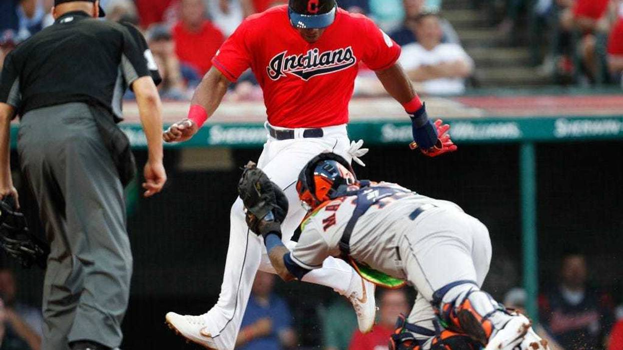 CLEVELAND, OH - AUGUST 01: Yasiel Puig #66 of the Cleveland Indians is tagged out at home plate by Martin Maldonado #12 of the Houston Astros in the fourth inning at Progressive Field on August 1, 2019 in Cleveland, Ohio. Puig and Maldonado are playing in