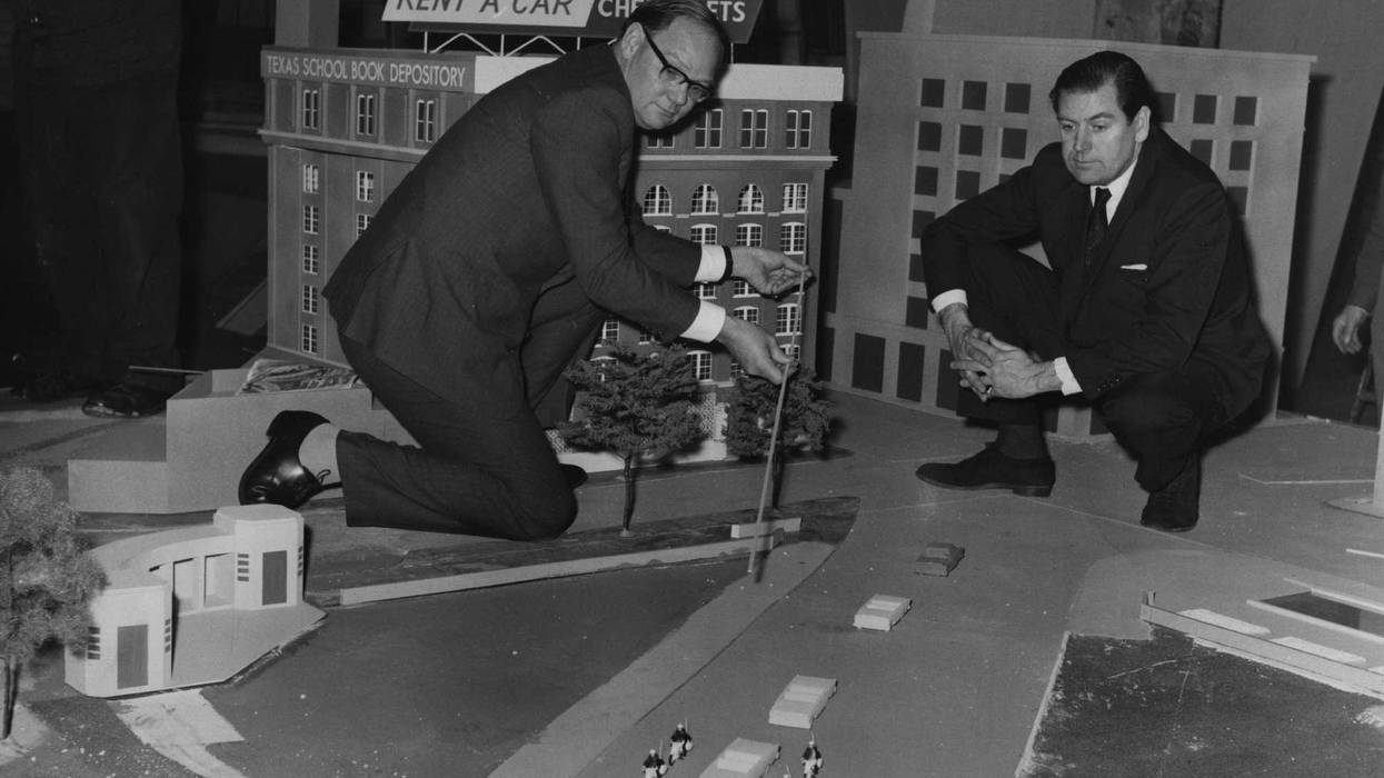 Cliff Michelmore pointing to the path of gun shots which killed President John F Kennedy, on a model reconstruction of Dealey Plaza, in Dallas, Texas.