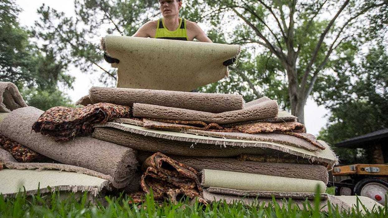 Cliff Watkins cleans up his parents house following the massive flooding, May 27, 2015 in Houston, Texas. Watkins, who grew up in the house, said this is the fifth time it has flooded since the 1970's and that one can't even get a home loan for the area without flood insurance. At least 19 people have been killed across Texas and Oklahoma after severe weather, including catastrophic flooding and tornadoes, struck over the past several days, with more rain expected. (Photo by Eric Kayne/Getty Images)