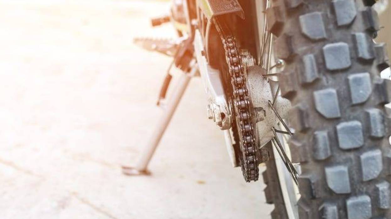 Close up of a dirt bike tire and chain.