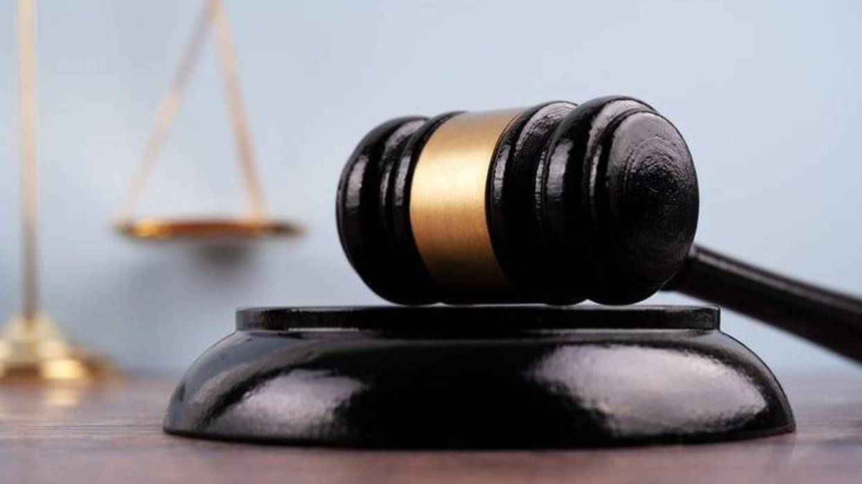 Close up of a gavel set with background of blurred image scales of justice.
