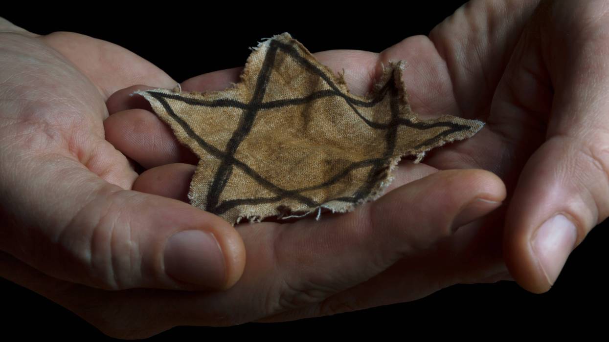 close up of hands holding a jewish star patch