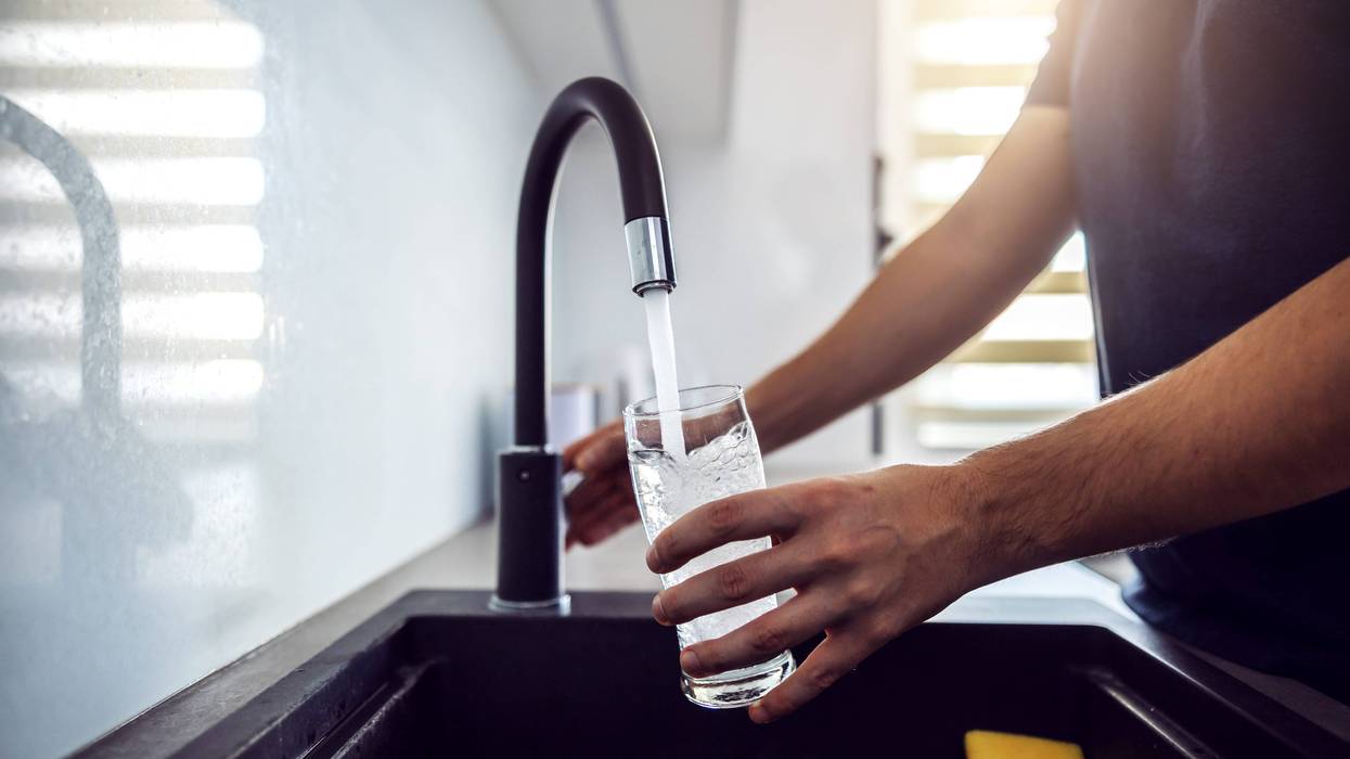 Close up of man pouring water from kitchen sink
