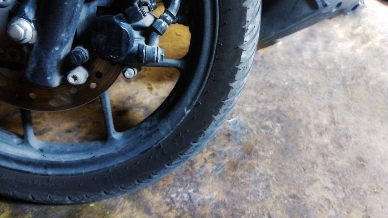 Close-up of motorcycle front tire with disc brake - stock photo