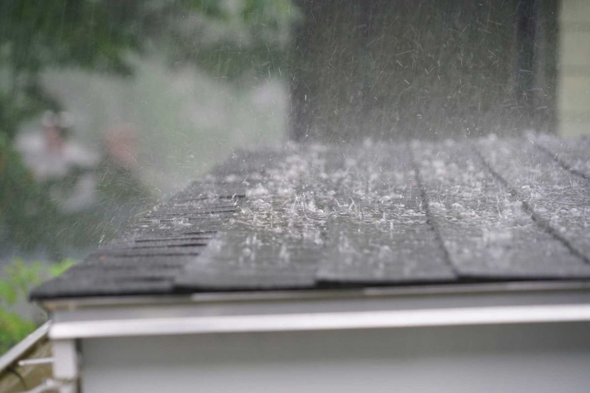 Close up of rain from a storm hitting a roof.