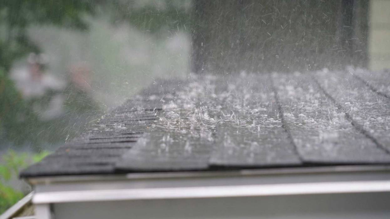 Close up of rain from a storm hitting a roof.