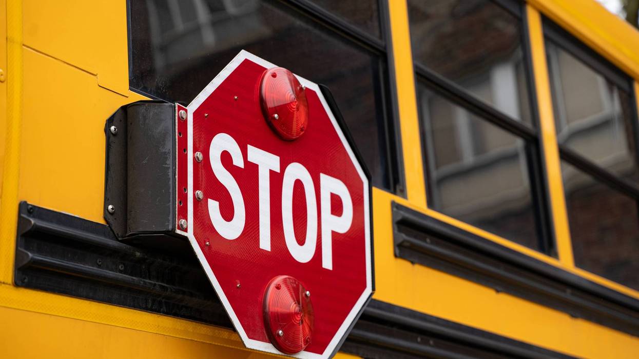 Close up of school bus stop sign with flashing red lights