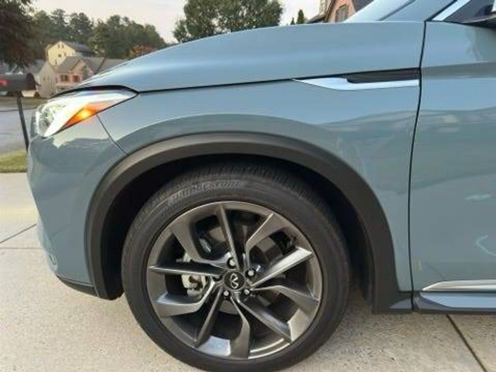 Close-up of the front wheel of a blue SUV, emphasizing its sleek design and vibrant color.