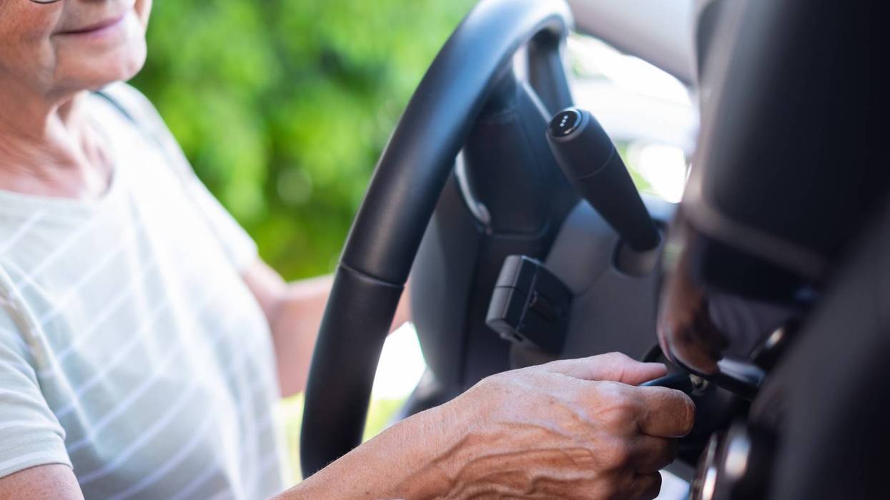 Close-up on senior woman hand in her car holding the key ready for drive and travel