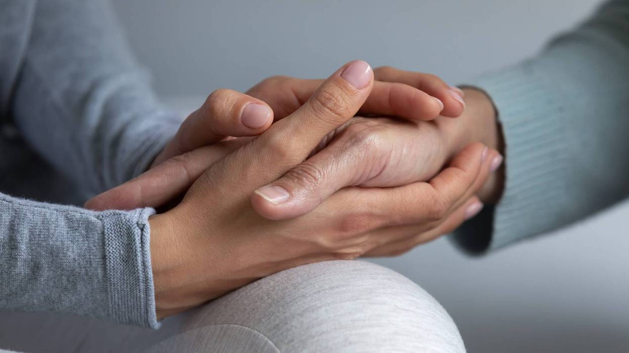 Close up young daughter comforting mature mother, granddaughter holding older grandmother hand, expressing love and support, good trusted family relationship, two generations, care to senior people