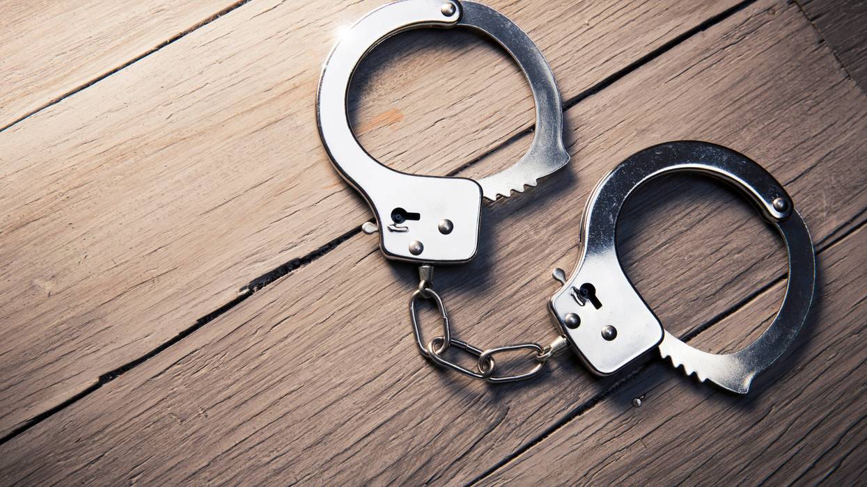 Closed handcuffs on a wooden background