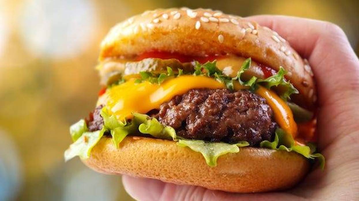 Closeup of a hand holding a hamburger
