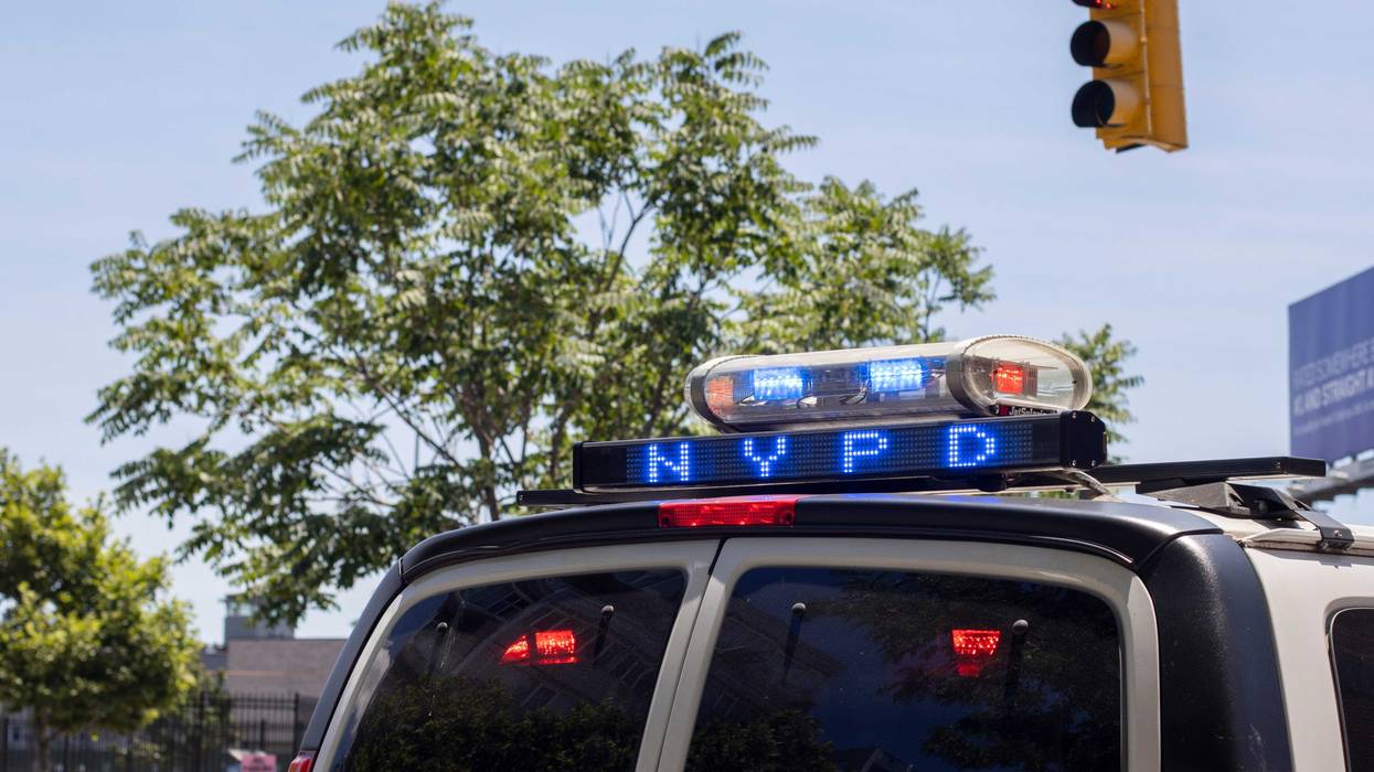 Closeup of a NYPD police car with flashing lights on the streets in the borough of Queens.