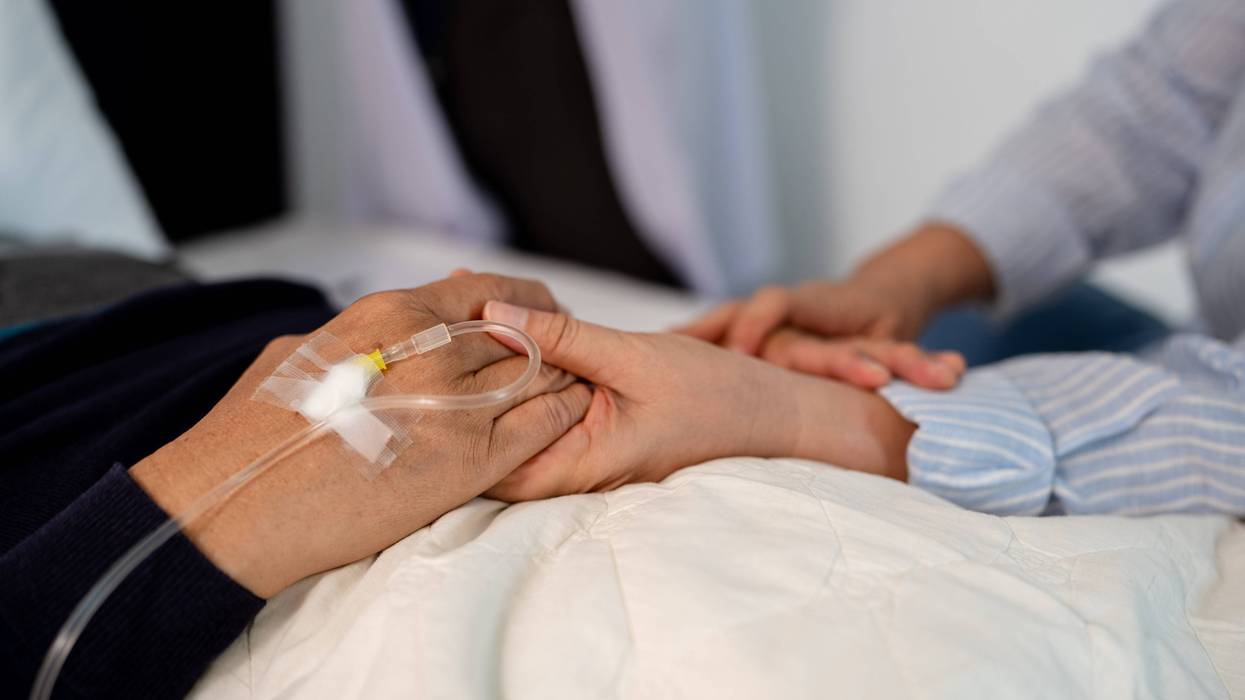Closeup of relative holding bedridden patient's hand