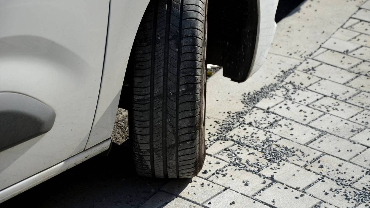 Closeup of wheel of car parked on sidewalk