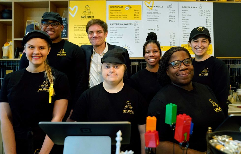 Co-founder of Café Joyeux Yann Bucaille-Lanrezac (3rd L) poses with employees at Café Joyeux