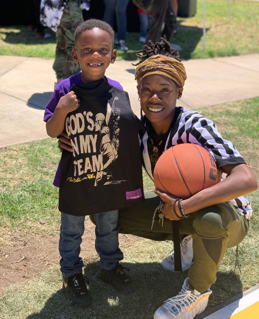 Coach La Tijera Avery standing next to child while holding basketball