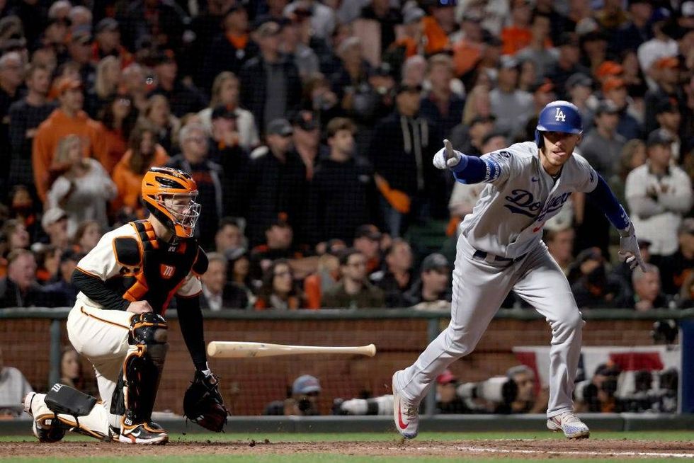 Cody Bellinger #35 of the Los Angeles Dodgers celebrates his RBI single to score Justin Turner #10 against the San Francisco Giants during the ninth inning in game 5 of the National League Division Series at Oracle Park on October 14, 2021 in San Francisco, California.