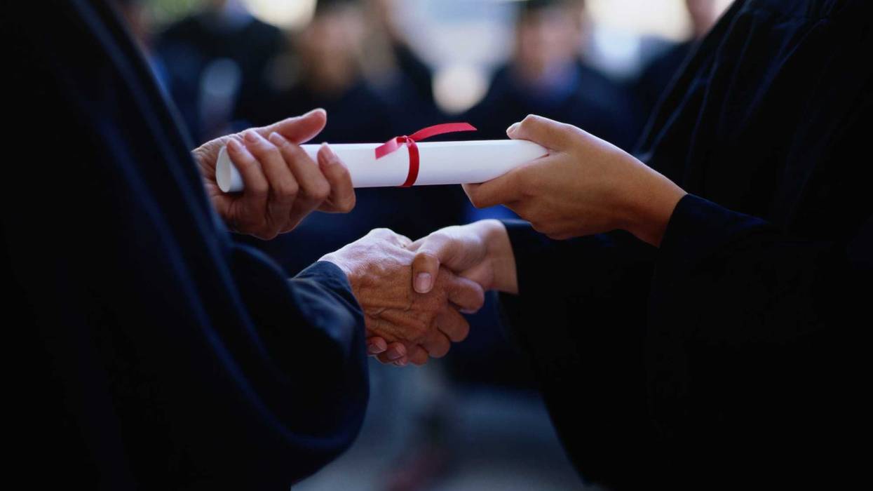 College graduate being handed their degree.