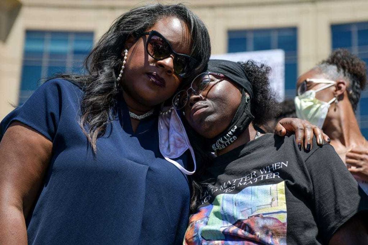 Colorado state representative Leslie Herod, left, hugs Elijah McClain's mother, Sheneen McClain, right, as they stand with protesters as they rally outside the Aurora Police Department Headquarters to demand justice for McClain's son on June 27, 2020 in Aurora, Colorado