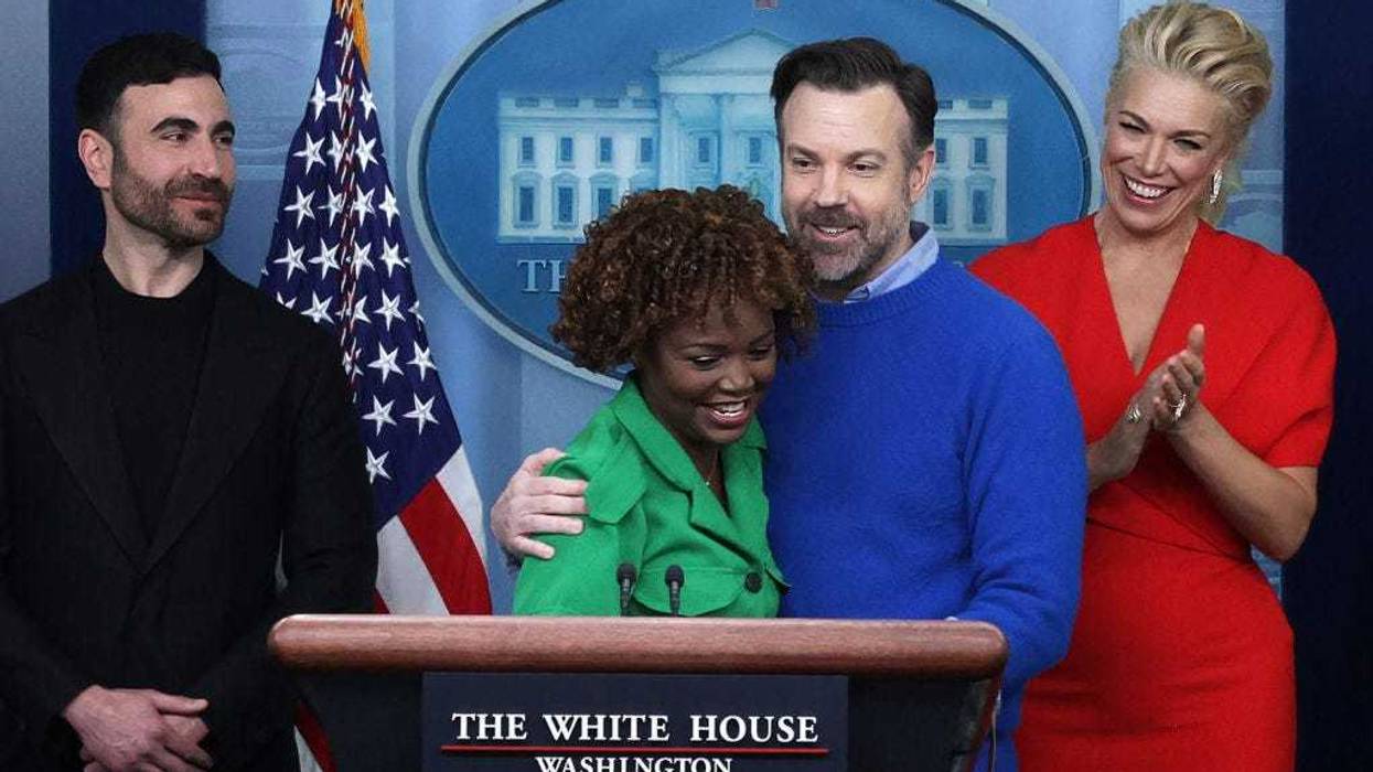 Comedian Jason Sudeikis of the Apple TV+ comedy series Ted Lasso embraces White House Press Secretary Karine Jean-Pierre as other cast members Brett Goldstein (L) and Hannah Waddingham look on during a White House daily news briefing at the James S. Brady Press Briefing Room on March 20, 2023 in Washington, DC. Sudeikis and the cast of Ted Lasso are at the White House to meet with President Joe Biden and first lady Jill Biden to discuss “the importance of addressing your mental health to promote overall well-being.” (Photo by Alex Wong/Getty Images)