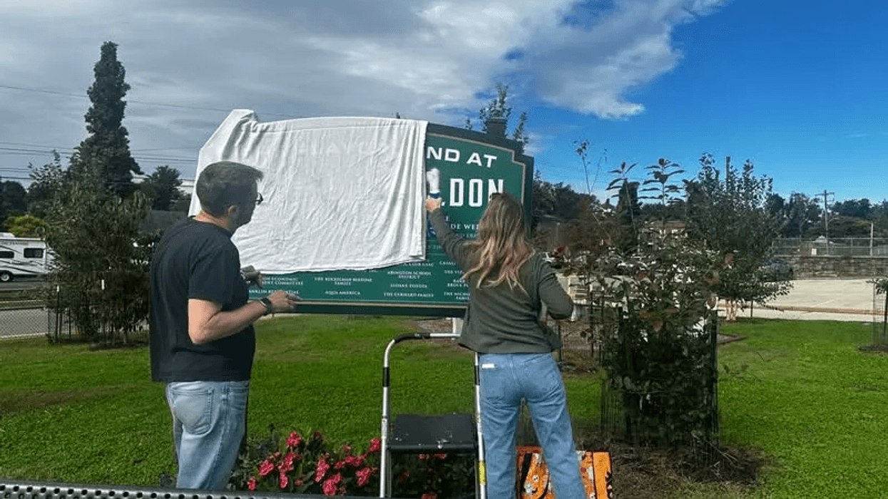 Community members cover up the racist, anti-semitic graffiti at Weldon Playground in Glenside.