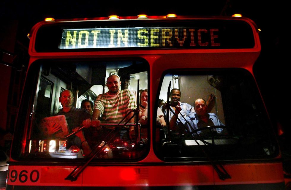 Commuters stand in a bus displaying "Not in Service" during a massive blackout on Aug. 15, 2003 in New York City