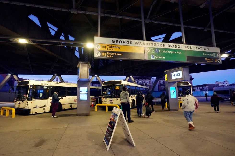 Commuters wait for buses at the George Washington Bridge Bus Station in New York, Friday, Dec. 6, 2024, where the gunman fleeing Wednesday