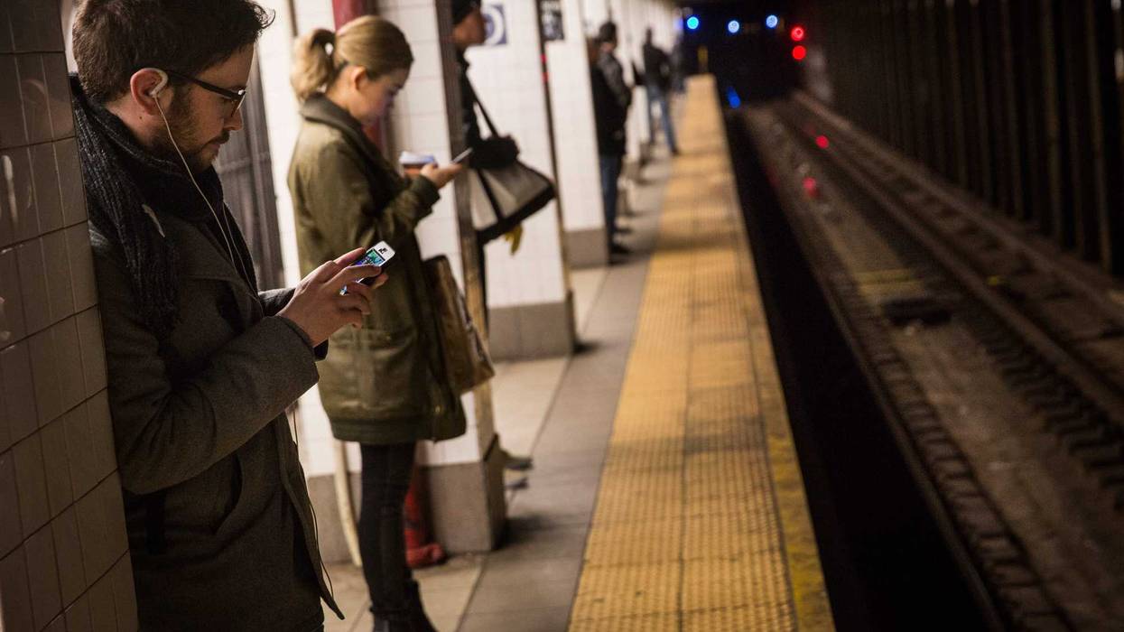 Commuters wait for the train at the Delancey Street-Essex Street subway station.