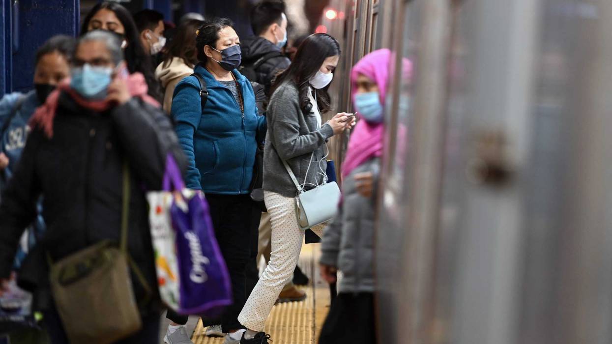 Commuters wear masks as they get on and off a subway train in Queens on May 3, 2022