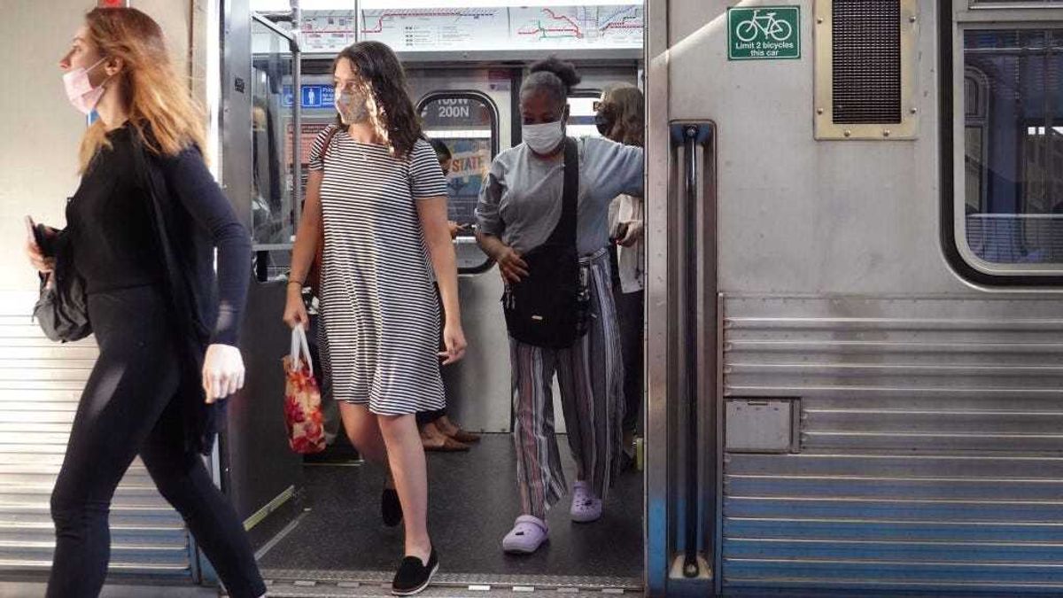 Commuters wearing face masks arrive in the Loop on an L train on July 27, 2021 in Chicago, Illinois.