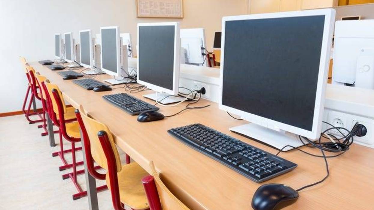 Computer lab with several desktops, keyboards and computer mouses.