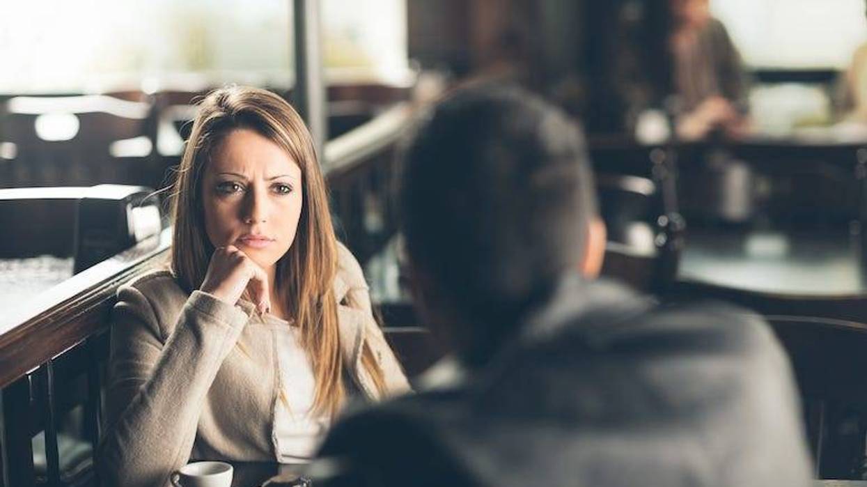 Concerned woman talking to man at restaurant