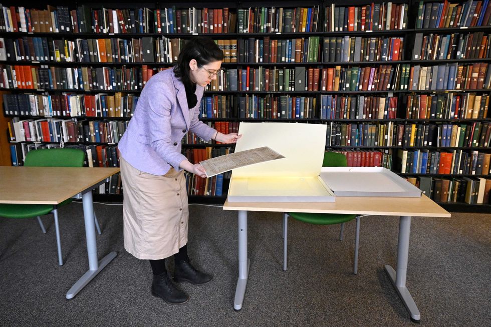 Connecticut Historical Society Collections Associate Julia Morrow displays an original complaint letter dated back to 1669 against Katherine Harrison, Tuesday, Jan. 31, 2023, in Hartford, Conn