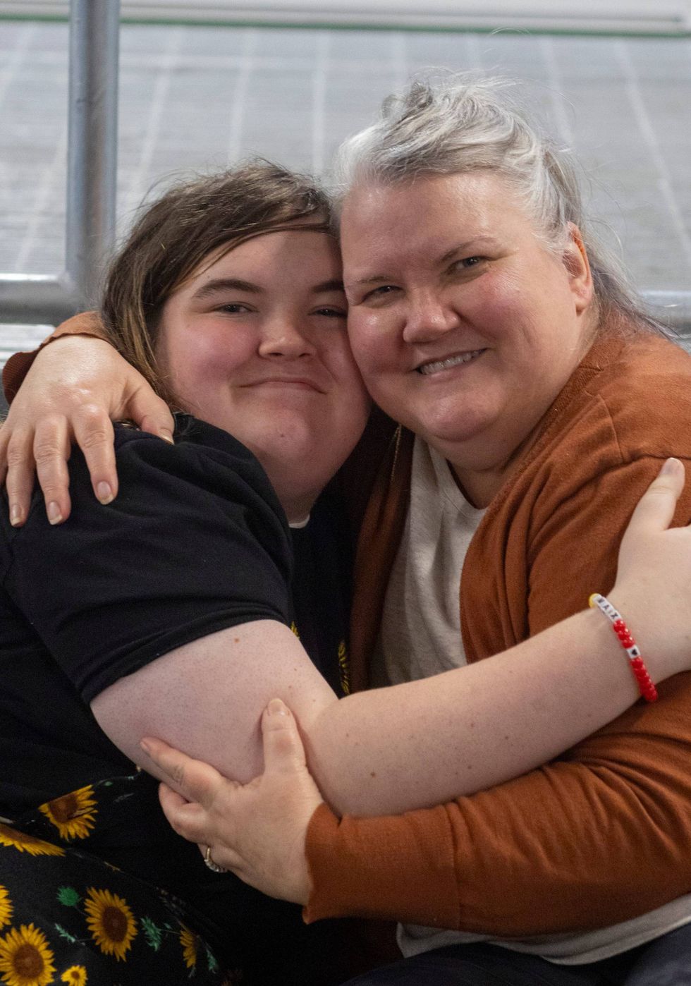 Connie Kathary and Julia Kathary hug each other while sitting for a portrait at a marketplace in Indianapolis, Indiana, in January.