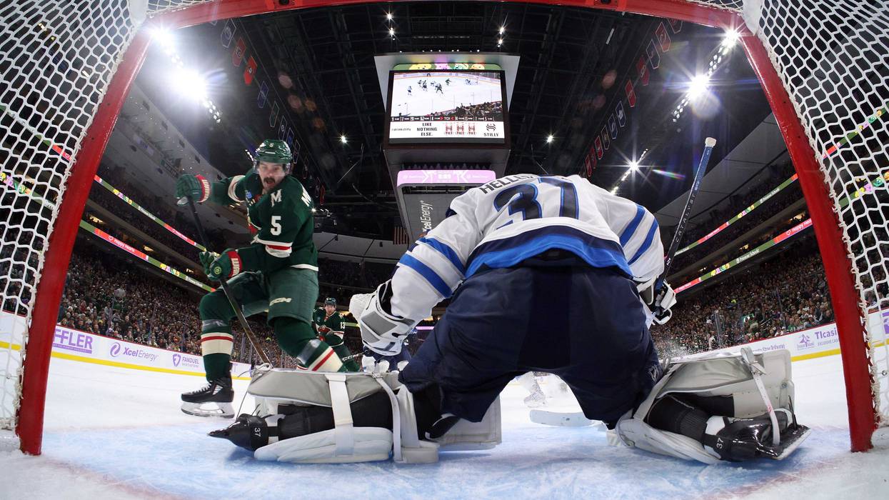 Connor Hellebuyck #37 of the Winnipeg Jets makes a save against Jake Middleton #5 of the Minnesota Wild in the second period at Xcel Energy Center on November 25, 2024 in St Paul, Minnesota. The Jets defeated the Wild 4-1.