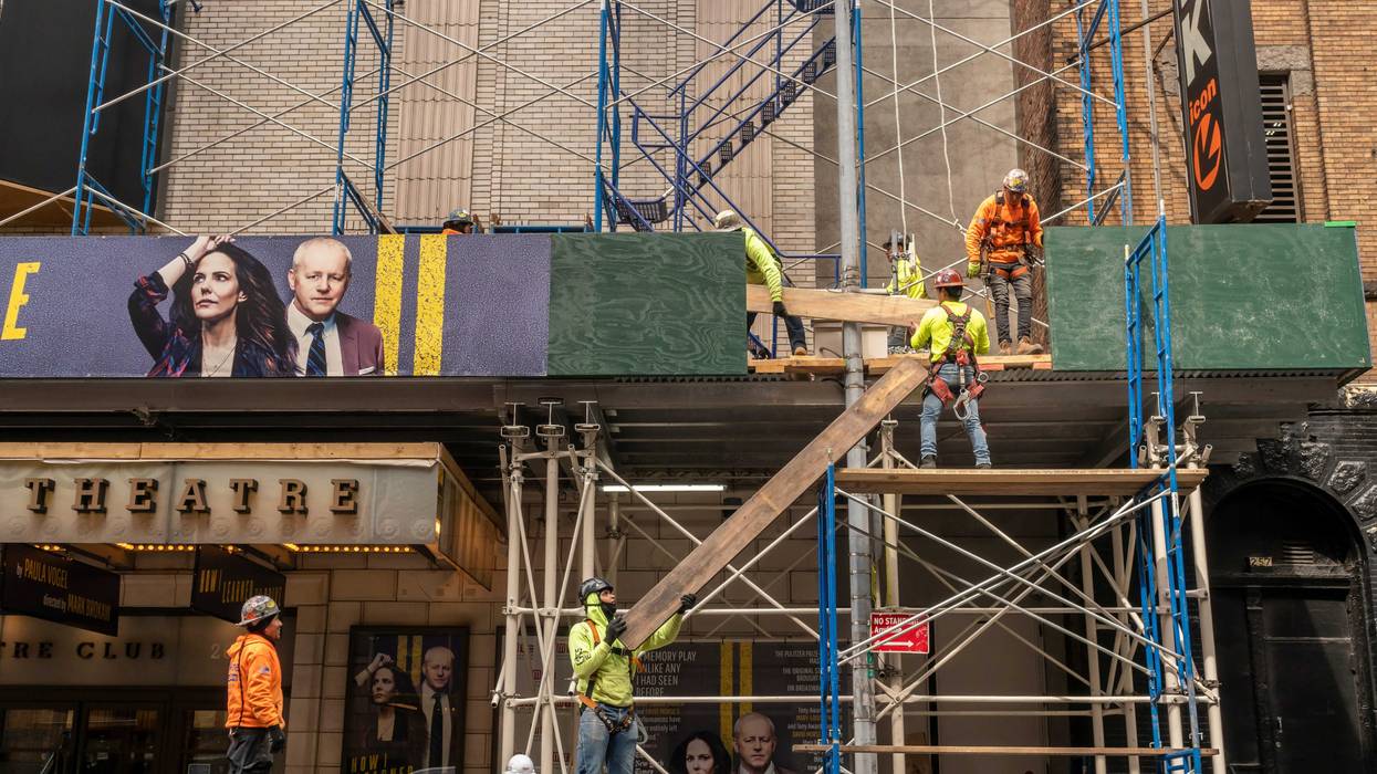 Construction crews work on a sidewalk shed on W. 47th Street near Times Square
