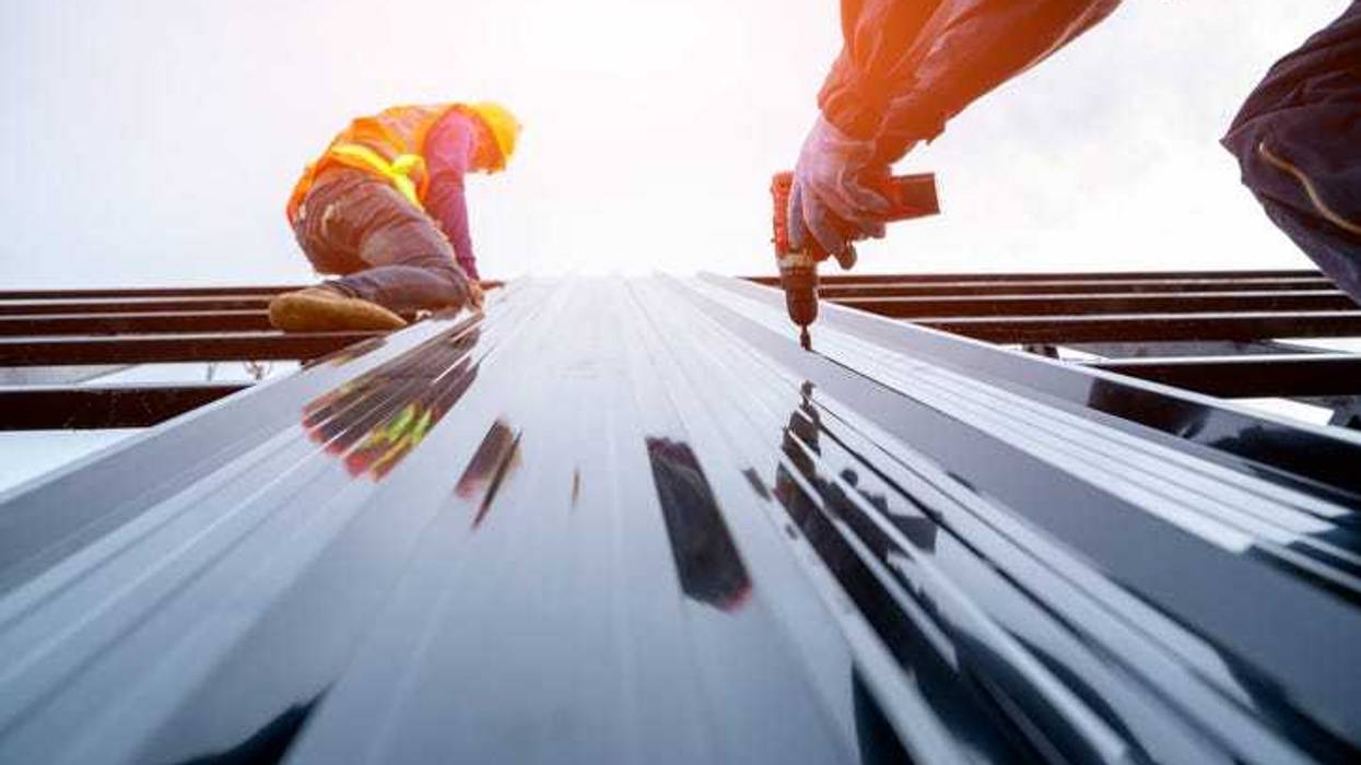 Construction worker building a metal house.