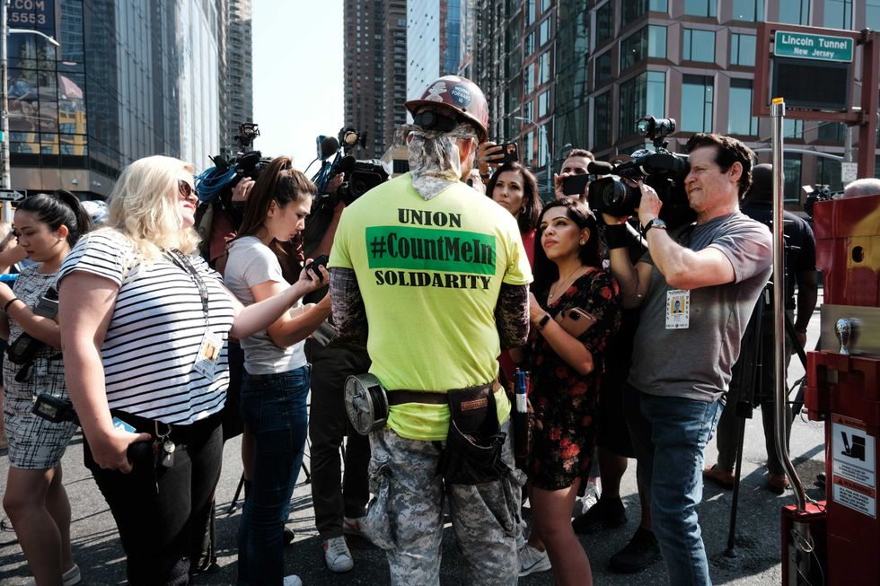 Construction worker Richard Paz tells news reporters about his escape from the crane collapse