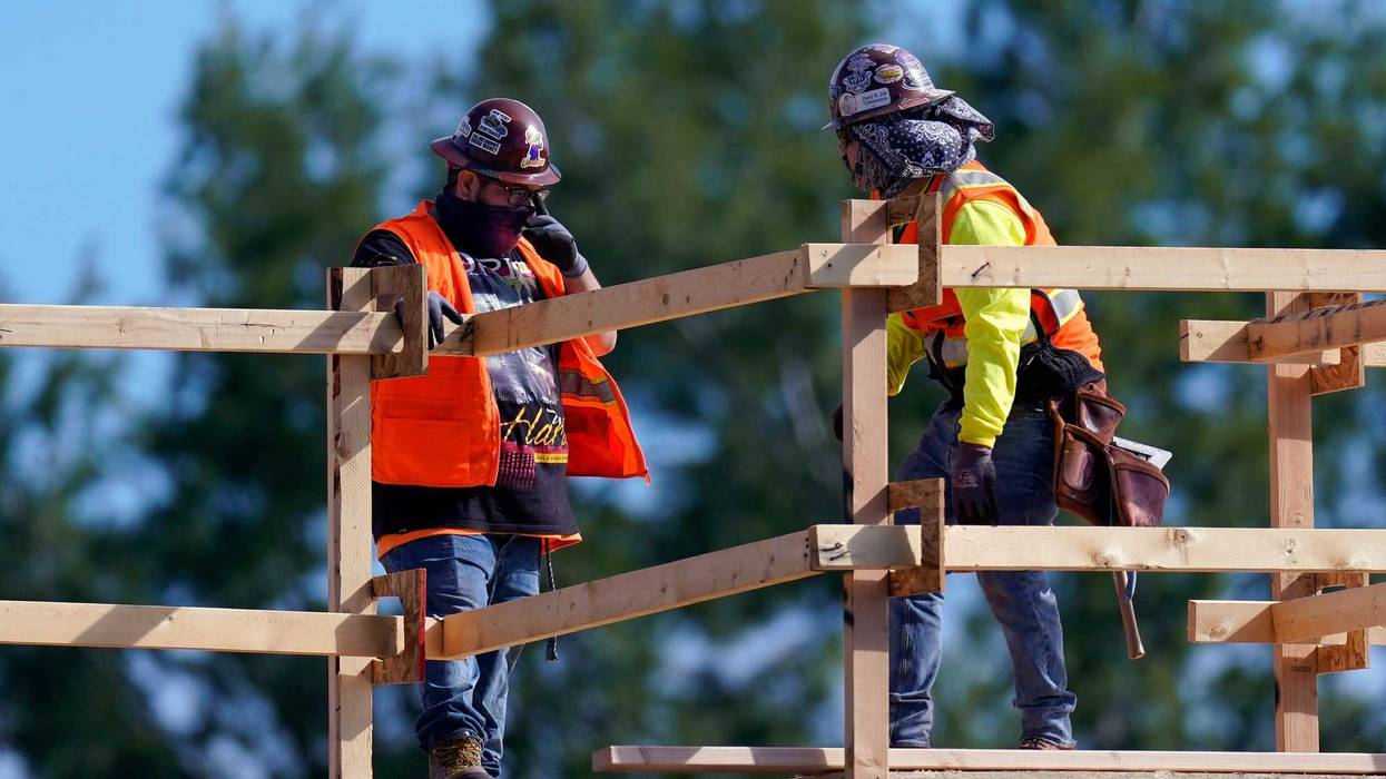 Construction workers talk at a USA Properties Fund site, Tuesday, Feb. 2, 2021, in Simi Valley, Calif
